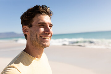 Young caucasian man smiling on the beach