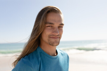 Young caucasian man smiling on the beach