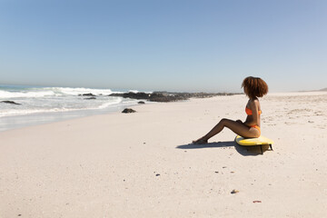 Mixed race woman sitting on the beach