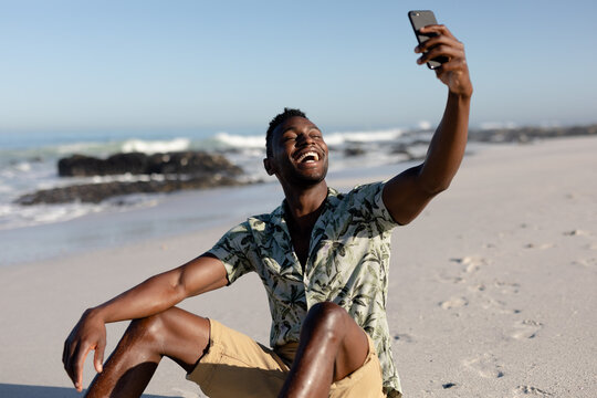 African american man taking a selfie on the beach