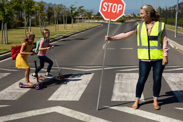 Woman wearing a high visibility vest and holding a stop sign