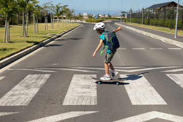 Schoolboy crossing the road on a skateboard © WavebreakMediaMicro