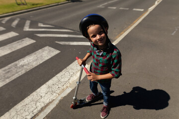 Schoolboy wearing a cycling helmet on a pedestrian crossing