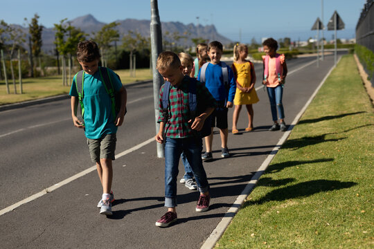 Group of elementary school pupils walking along a road