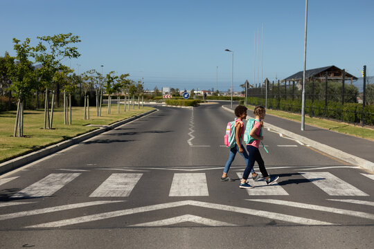 Schoolgirls crossing the road on a pedestrian crossing