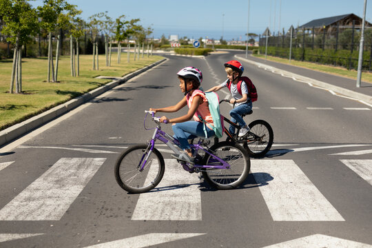 Schoolgirls crossing the road with bicycles