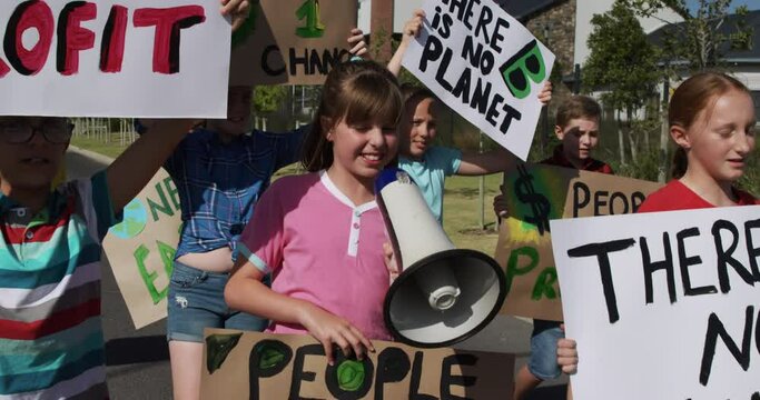 Group of kids with climate change signs and megaphone in a protest