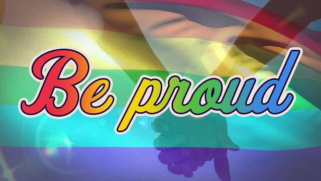 Animation of be proud text with rainbow colours on waving equality rainbow flag and couple
