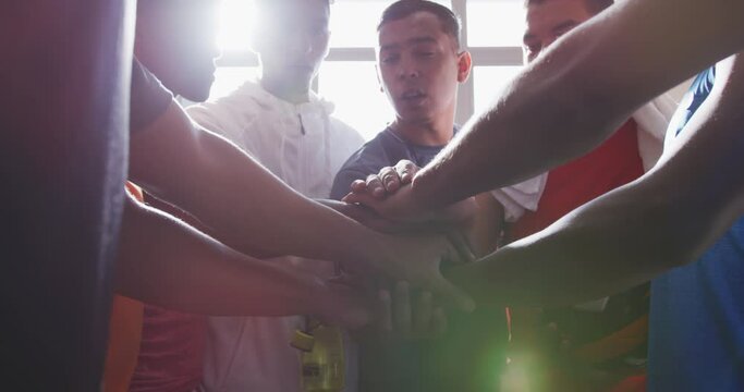 Coach and soccer players motivating in the locker room