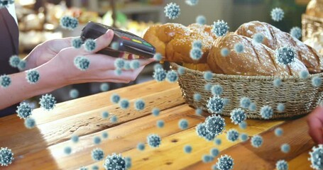 Animation of coronavirus cells spreading and customer making contactless payment - Powered by Adobe