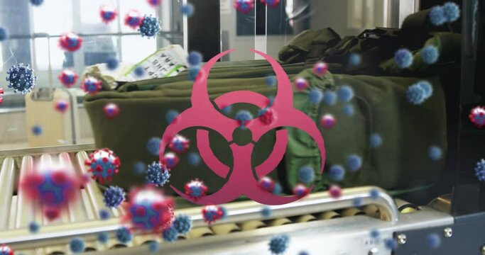 Animation of floating macro Covid-19 cells and biohazard symbol over moving baggages at airport