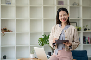 Asian woman working in office with laptop and tablet online working concept