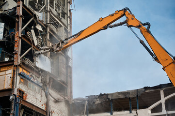 Fototapeta na wymiar Hydraulic scissors on rig of crane cut building on site