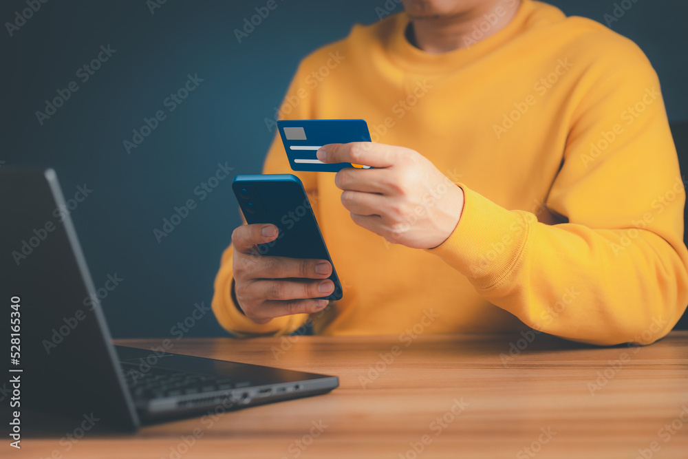 Poster a man using credit card for purchasing and shopping online on mobile phone. mobile payment with wall