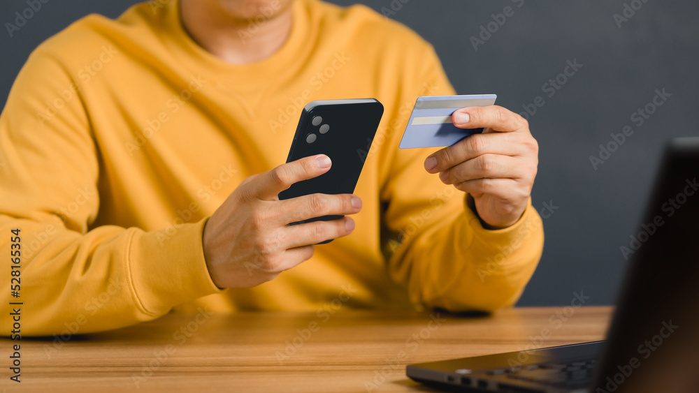 Poster a man using credit card for purchasing and shopping online on mobile phone. mobile payment with wall