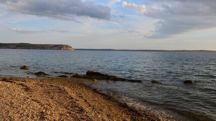  Late afternoon clouds above pebble beach. Bay near Razanac, northern Dalmatia, Croatia. Some mild waves visible. 
