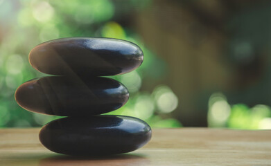 Spa black and white stone stack on wooden table, concept of balance and harmony.