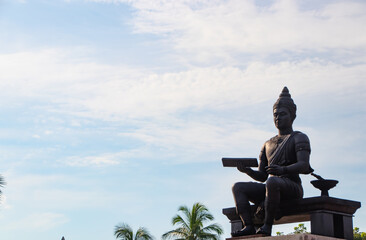 King Ramkhamhaeng Monument in Sukhothai Historical Park, Thailand. Ancient Thai king statue holding scripture with traditional attire under blue sky, famous cultural landmark 