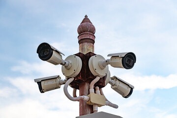 Multiple CCTV cameras mounted on poles, many CCTV cameras with blue sky in the morning