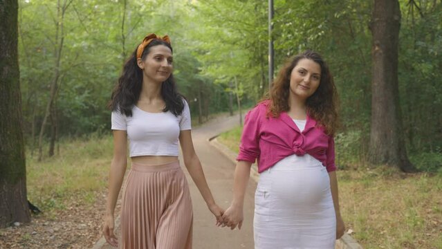 Pregnant Lesbian Couple Stroll And Twirl Around Park Loving LGBTQ Parenting