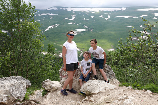 Mother with her sons on rock of Lago-Naki plateau in Adygea