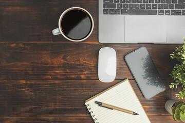 Top view old wood desk office with laptop, notebook, coffee of cup and a pen on wood background. Business office for meeting concept..Background with copy space.