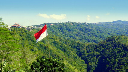hoher Kraterrand vom Vulkan Batur in Bali mit grünem Wald unter blauem Himmel mit indonesischer...