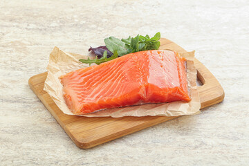 Raw salmon fillet over board
