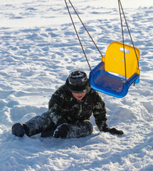 The boy fell from a swing into the snow