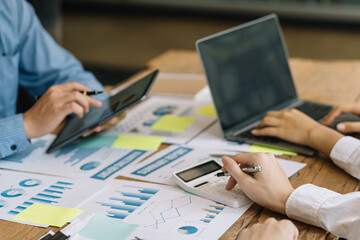 Close-up of hands of a group of business people working together in the office meeting and planning new marketing idea, presenting new business project and analyzing quarterly earning.