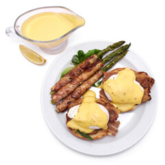 Healthy food - Asparagus wrapped with bacon and benedict poached eggs on a plate isolated on white background