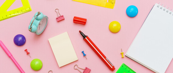 Stationery colorful writing supplies pens pencils blockton on spring, colored paper pink background. Back to school. Office supplies