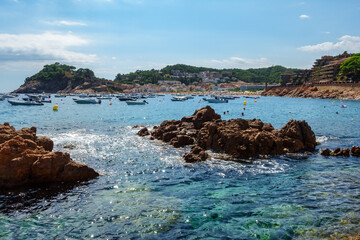 Rocks in the sea and golden sand beaches with medieval castle in Tossa de Mar, Gerona, Spain.
