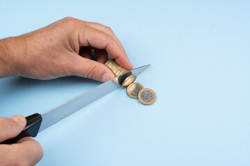 the gesture of cutting Euro coins with the knife. concept of installment payment of debt.