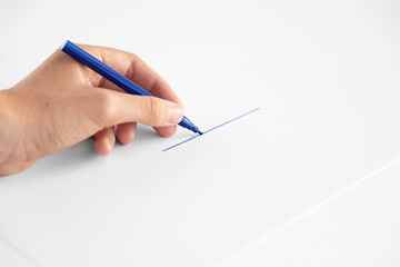 Blue marker in hand. A woman draws a line with a felt-tip pen on a white background.