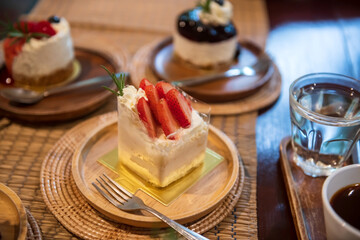 strawberry and blueberry cakes and hot coffee on wooden table