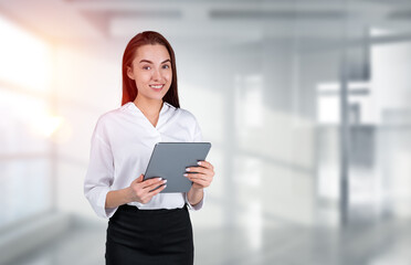 Smiling businesswoman wearing formal wear is standing holding ta