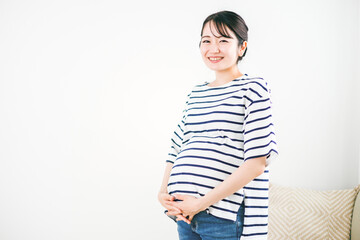部屋にいる妊婦（笑顔・カメラ目線）
