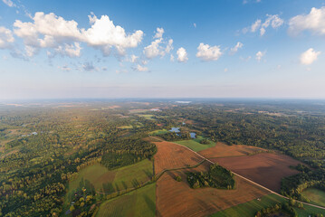 Aerial view of fields, forests and lake on a sunny summer morning, Latvia.