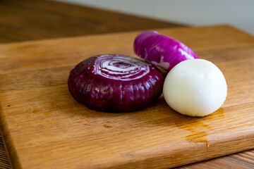 red and white onions on a wooden cutting board