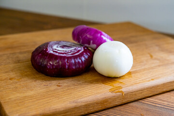 red and white onions on a wooden cutting board