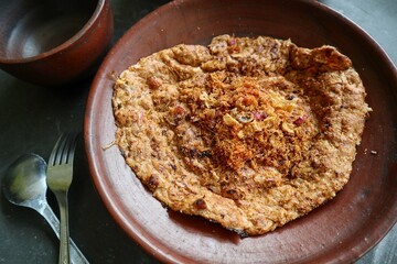 kerak telor or Egg Crust. kerak telor is Spicy Glutinous Rice Omelette with Grated Coconut. made from glutinous rice cooked, egg, serundeng, fried shallots and dried shrimp topping.