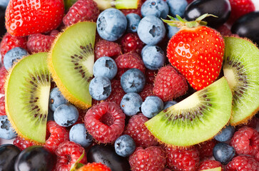 Obraz premium Fruits. Background of sweet berries and kiwi. Fresh fruit closeup.
