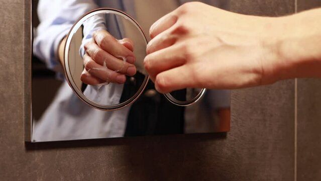 Female hand pressing silver toilet flush button on the wall after using. Reflaction of woman in a metal surface. Wc with two separate buttons for economical use of water. High quality 4k footage