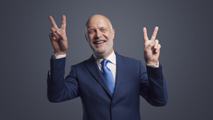 Cheerful businessman making a V sign