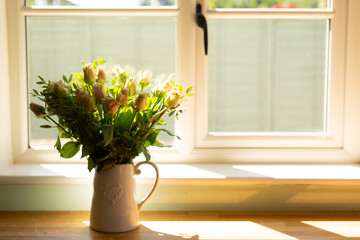 A bouquet of roses in a white jug