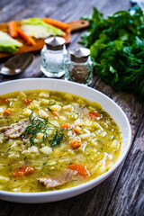 Bowl of hot cabbage soup on wooden table
