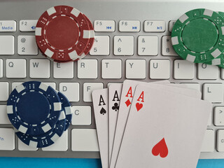 Computer keyboard four aces and cards casino chips and dice closeup