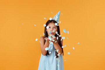 birthday child girl blowing confetti off her hands