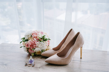 Wedding bouquet of the bride of pink flowers roses and greenery, stylish classic lacquered beige...
